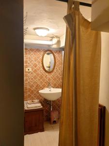 a bathroom with a sink and a mirror at Helga's House- Una Finestra sul Borgo in Ambra