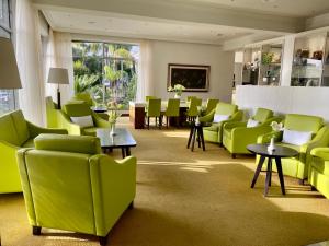 una sala de espera con sillas y mesas verdes en Hotel Tigaiga, en Puerto de la Cruz