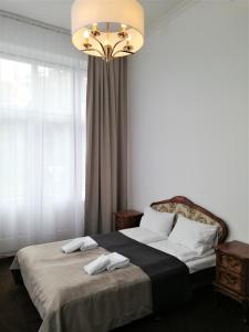 a bedroom with a bed and a chandelier at Rewita Rusałka in Sopot