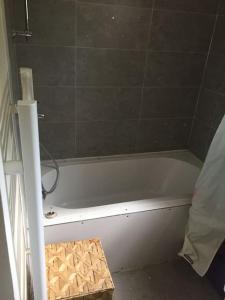 a bathroom with a white bath tub in a room at Chambre double Futon et Chambre Classique au coeur du Vercors in Saint-Agnan-en-Vercors