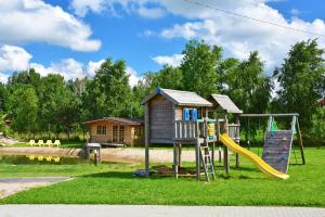 a playground with a house and a slide at Auroradream in Motiejiškės