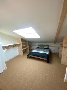1 dormitorio en el ático con 1 cama y tragaluz en Maison de charme au cœur des vignes et Gironde, en Gauriac