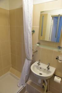 a bathroom with a sink and a shower curtain at CORBIERE GUEST HOUSE in Weston-super-Mare