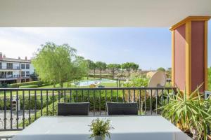 balcón con mesa, sillas y piscina en Esurigolf Ayamonte Pequeño paraiso en el Algarve Español Entrada Lunes, en Ayamonte