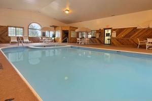 a large swimming pool with blue water in a building at Super 8 by Wyndham Coshocton Roscoe Village in Coshocton
