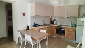 kuchnia z drewnianym stołem i białymi urządzeniami w obiekcie Ismini Apartments Myrtos w mieście Myrtos