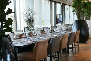 a long table with glasses and chairs in a room at NH Collection Olomouc Congress in Olomouc