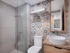 ein Badezimmer mit Toilette, Waschbecken und Dusche in der Unterkunft Fika Rooms Tangerang By Skandinavia in Tangerang