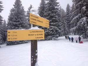 Un cartel en la nieve con gente caminando en la nieve. en Duplex Superbe Vue Montagne, en La Bourboule 8 fotos más