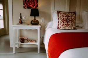 a bedroom with a bed and a table with a lamp at el gran sueño Boutique Hotel & Apartamentos - Adults Only in Pintueles