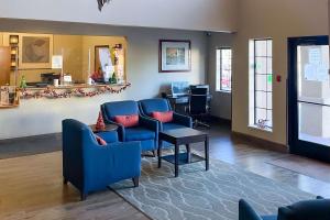 una sala de espera con sillas azules y una mesa en Comfort Inn & Suites Midtown, en Ruidoso