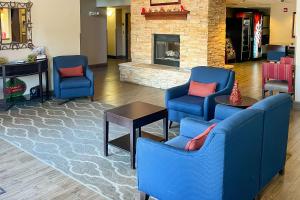 vestíbulo con 2 sillas azules y chimenea en Comfort Inn & Suites Midtown, en Ruidoso