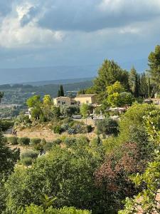 ein Dorf auf einem Hügel mit Bäumen und Häusern in der Unterkunft Castel'lodge in Le Beausset