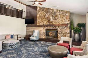 a living room with a stone wall with a fireplace at AmericInn by Wyndham Rapid City in Rapid City