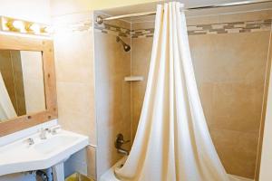 a bathroom with a shower curtain and a sink at Rodeway Inn Albuquerque Downtown on Rt 66 in Albuquerque +22 photos