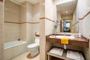 a bathroom with a sink and a toilet and a tub at Lodging Apartments Liceu G2 in Barcelona