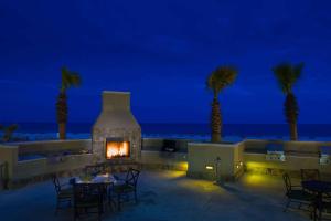 a fireplace on a patio with palm trees and the ocean at Escapes! To The Shores Orange Beach, A Ramada by Wyndham in Orange Beach