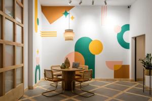 a dining room with a table and chairs and a wall with colorful graphics at BYPILLOW La Sal in Cádiz