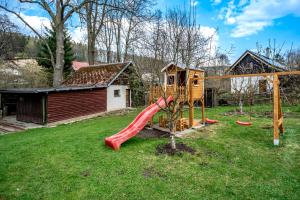 a playground with a slide in a yard at Chalupa U Potoka in Malá Morávka