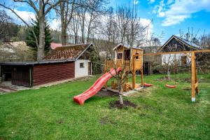 un parque infantil con un tobogán en un patio en Chalupa U Potoka en Malá Morávka