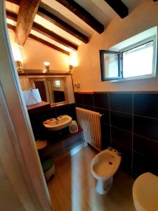 La salle de bains est pourvue d'un lavabo, de toilettes et d'une fenêtre. dans l'établissement Charming 4-Bed Cottage 15 minutes from Florence, à Impruneta