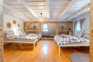 sala de estar con 3 camas y suelo de madera en Chalupa U Potoka, en Malá Morávka
