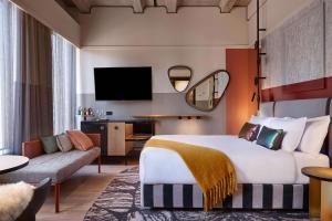 奧克蘭的住宿－QT Auckland，酒店客房设有一张大床和一张沙发。