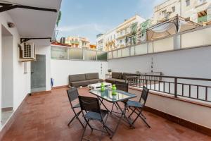 um pátio com uma mesa e cadeiras numa varanda em Lodging Apartments Liceu 11 em Barcelona