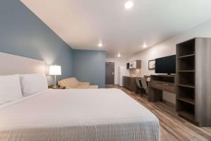 a hotel room with a large bed and a desk at WoodSpring Suites Philadelphia Northeast in Philadelphia