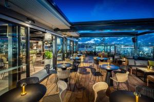 ein Restaurant mit Tischen und Stühlen und Stadtblick in der Unterkunft QT Auckland in Auckland