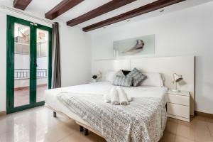 ein weißes Schlafzimmer mit einem Bett und einem Fenster in der Unterkunft Lodging Apartments Liceu 11 in Barcelona