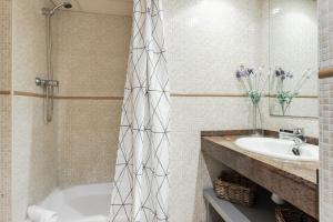 ein Badezimmer mit einer Badewanne und einem Waschbecken in der Unterkunft Lodging Apartments Liceu 11 in Barcelona