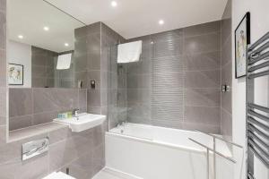 łazienka z wanną, umywalką i wanną tubermottermott w obiekcie STYLISH 2 BED 2 BATH IN HIGHGATE & FREE PARKING w Londynie