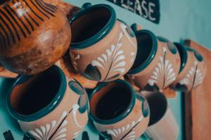 a bunch of vases are hanging on a wall at La Casa del Kéej Hostel in Mérida