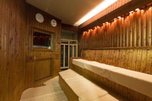 a sauna with wooden walls and benches and clocks at Nagoya B's Hotel in Nagoya