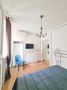 a bedroom with a bed and a blue chair at Via Vittoria Quattro in Rome