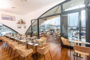een eetkamer met tafels en stoelen en een jachthaven bij Locanda da Toto in Genua