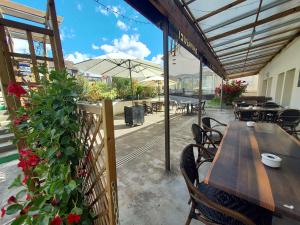 patio con tavolo, sedie e ombrellone di Hôtel le Comtois a Saône