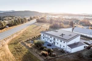 une vue aérienne d'une maison blanche sur le côté d'une route dans l'établissement Land-gut-Hotel am Ring, à Meuspath