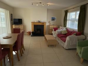 a living room with a couch and a table at Castle Gardens Bungalow, Saint Helens Resort, Wexford - 3 Bedroom Sleeps 6 in Ballygerry