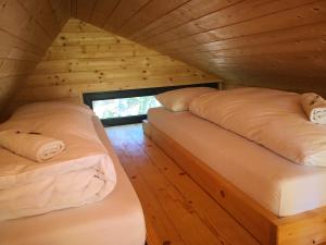 a bedroom with two beds in a wooden cabin at Mountain lodge Forte Emilia in Kobarid