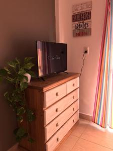 un comò con una tv sopra di DEPARTAMENTO PARA DOS PERSONAS EN ZONA CENTRICA a Zárate