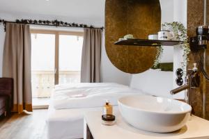 baño con lavabo y cama en Seehotel Berau en St. Wolfgang