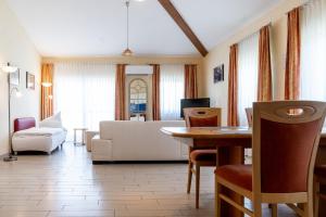 uma sala de estar com um sofá e uma mesa em Land-gut-Hotel am Ring em Meuspath