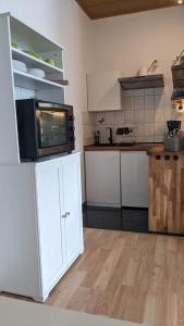 eine Küche mit einer Mikrowelle auf dem Kühlschrank in der Unterkunft Meiers FeWo in Tremmen
