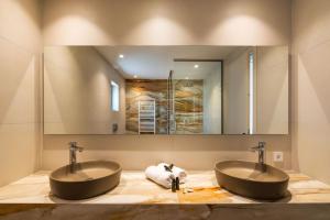 two sinks in a bathroom with two mirrors at El Greco in Igoumenitsa