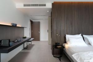a hotel room with a bed and a desk with a tv at El Greco in Igoumenitsa