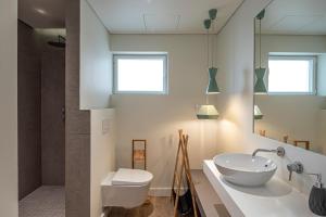 ein Badezimmer mit einem weißen Waschbecken und einem WC in der Unterkunft Cascais Bay Terrace ii in Cascais