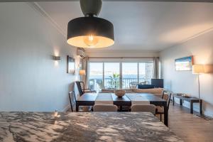 ein Esszimmer und ein Wohnzimmer mit einem Tisch und Stühlen in der Unterkunft Cascais Bay Terrace ii in Cascais