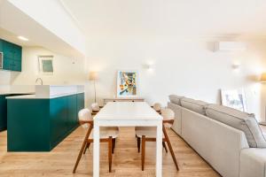 a kitchen and living room with a white table and a couch at Cascais Bay Terrace iii in Cascais